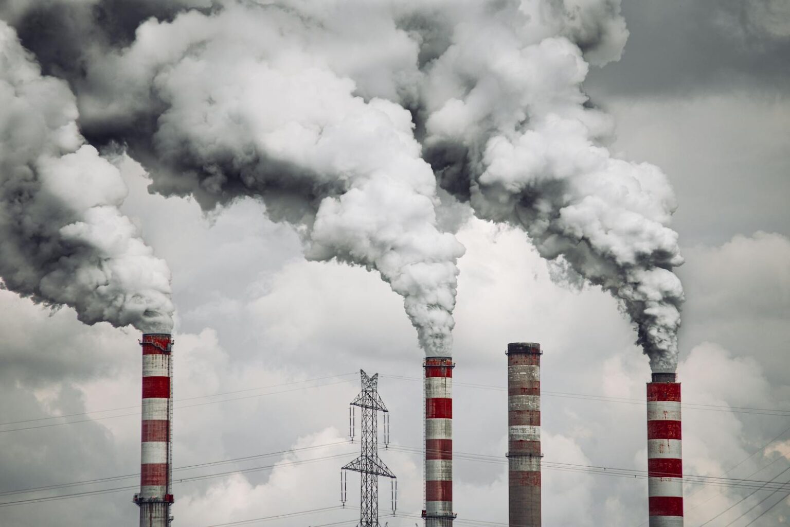 Smoke billows from factory chimneys in Konin, Poland, highlighting pollution and environmental impact.