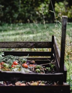 Wooden compost bin in an Estonian garden with organic waste and vegetables.