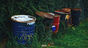 a row of trash cans sitting on top of a lush green field