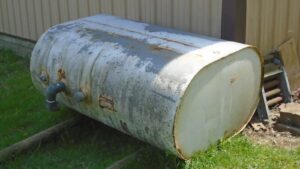 a large metal barrel sitting on top of a lush green field