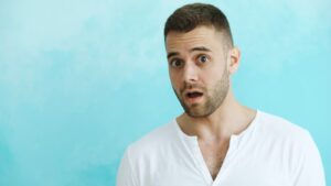 Man with surprised expression against blue background